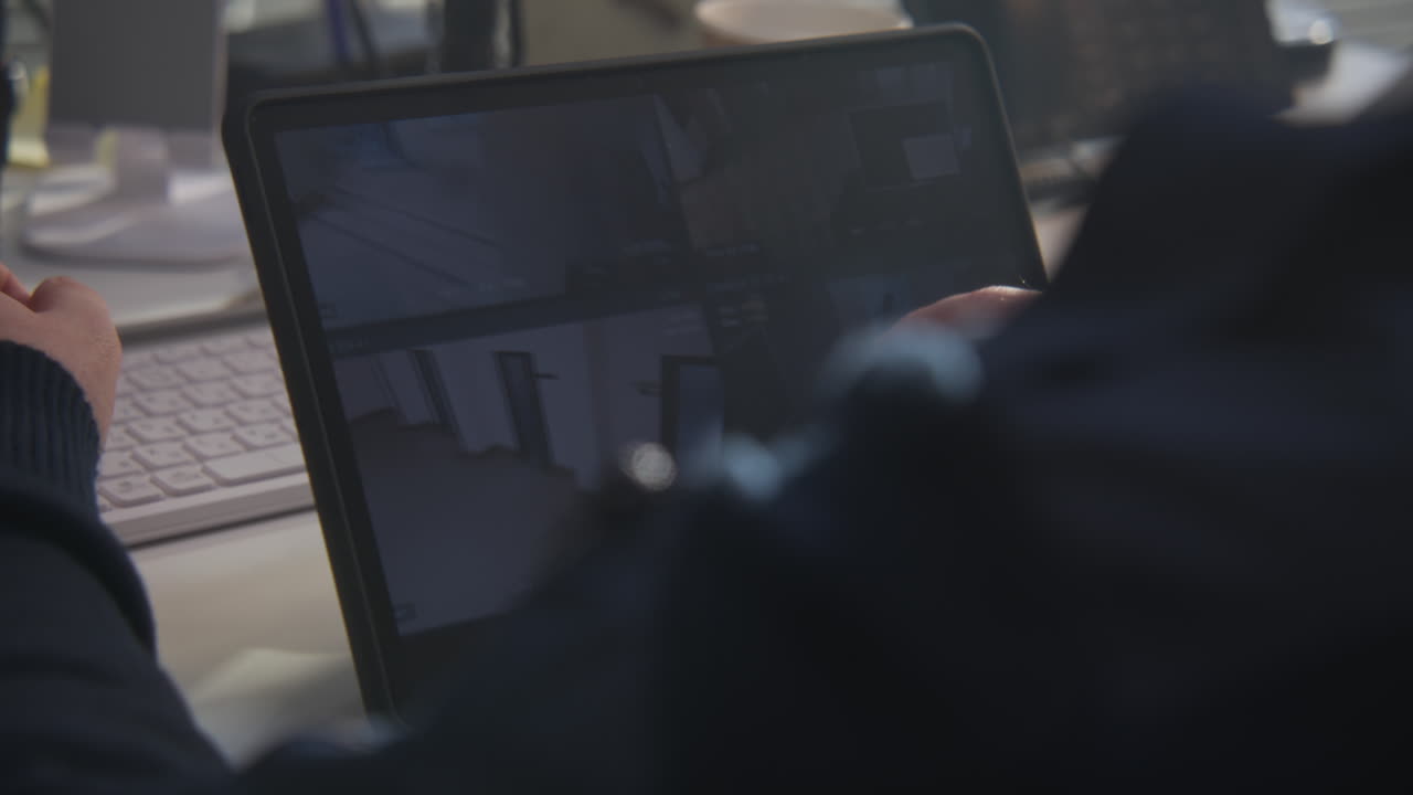 Person monitoring security cameras on a tablet