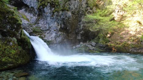 Vista-De-Drones-En-Albania-En-Los-Alpes-Volando-Frente-A-Una-Cascada-Rodeada-Por-La-Montaña-Rocosa-Y-Verde-En-Theth