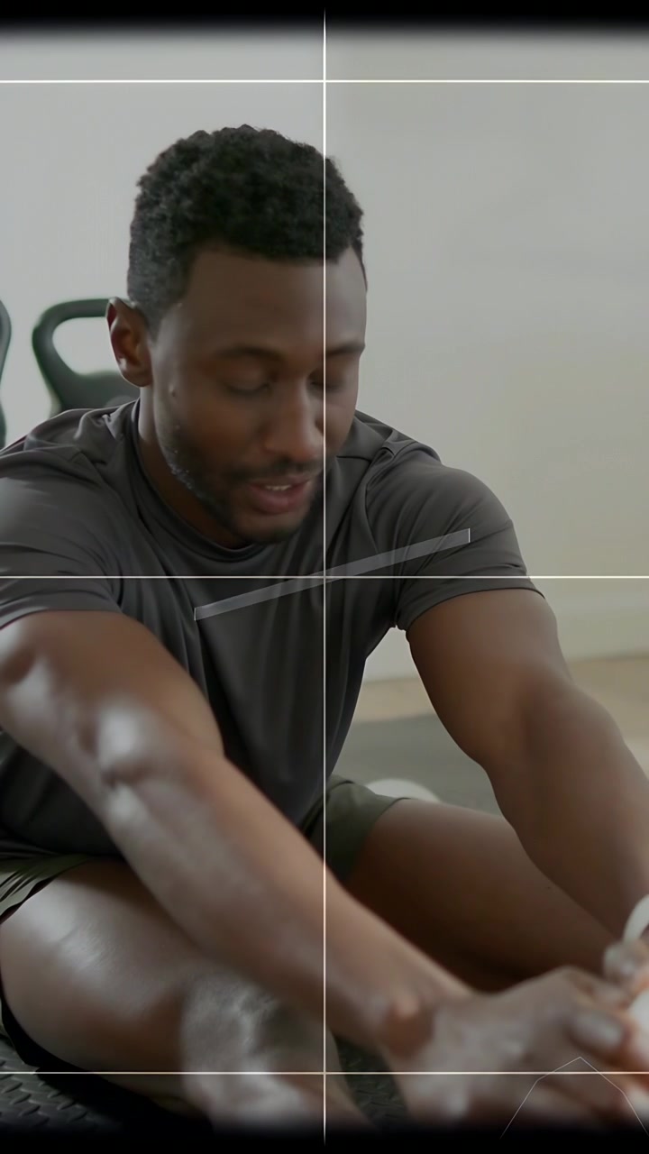 Video verticale: Uomo che inizia uno stretching da seduto, raggiungendo i piedi, dando un'occhiata mentre un HUD scorre per il fitness.
