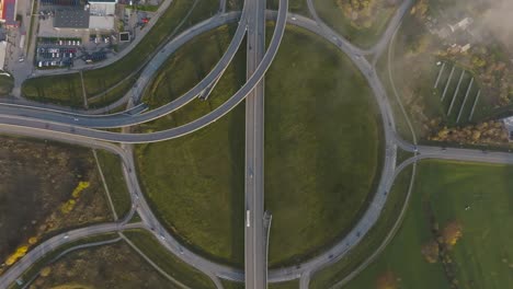 Eine-Luftaufnahme-Eines-Großen-Kreisverkehrs-Mit-Brücken-Und-Gehwegen-Außerhalb-Der-Stadtgrenzen-Für-Autos-Und-Lastwagen