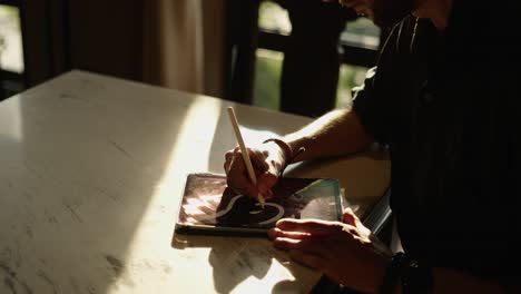 a person drawing or creating digital art on a tablet with a stylus
