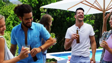 grupo de amigos bailando mientras toman bebidas en una fiesta de barbacoa al aire libre