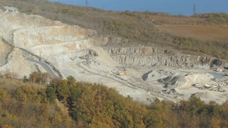 aerial view of an open-pit quarry with mining equipment and workers