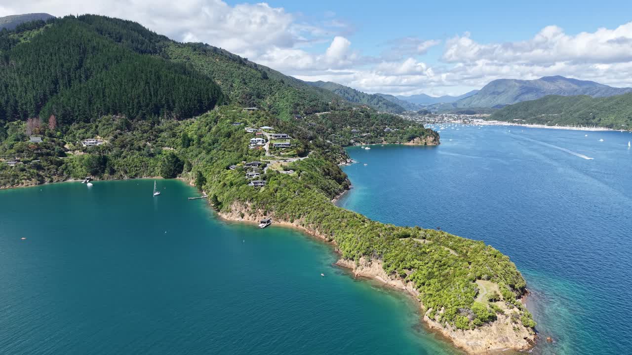 Luftopptak i revers over vakkert turkist vann om sommeren ved Karaka Point, Queen Charlotte Sound, New Zealand.