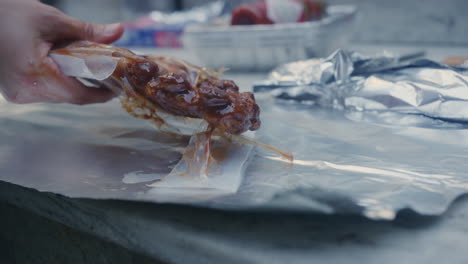 desenvolver costillas a la barbacoa preparadas previamente sobre la mesa