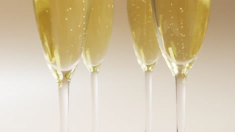 video of champagne in glasses on beige background