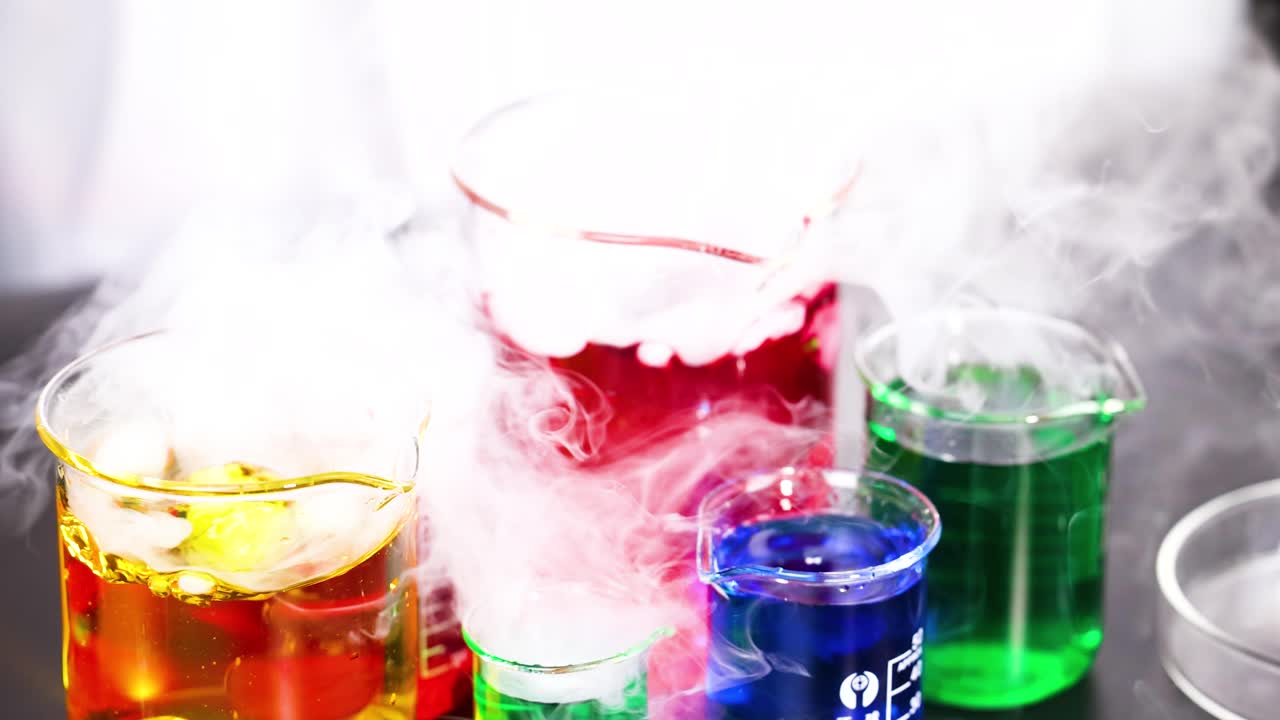 연기를 방출하는 다채로운 액체가 있는 컵