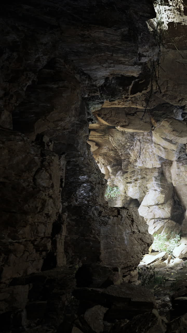 Ingresso di una grotta con luce che filtra attraverso formazioni rocciose al crepuscolo