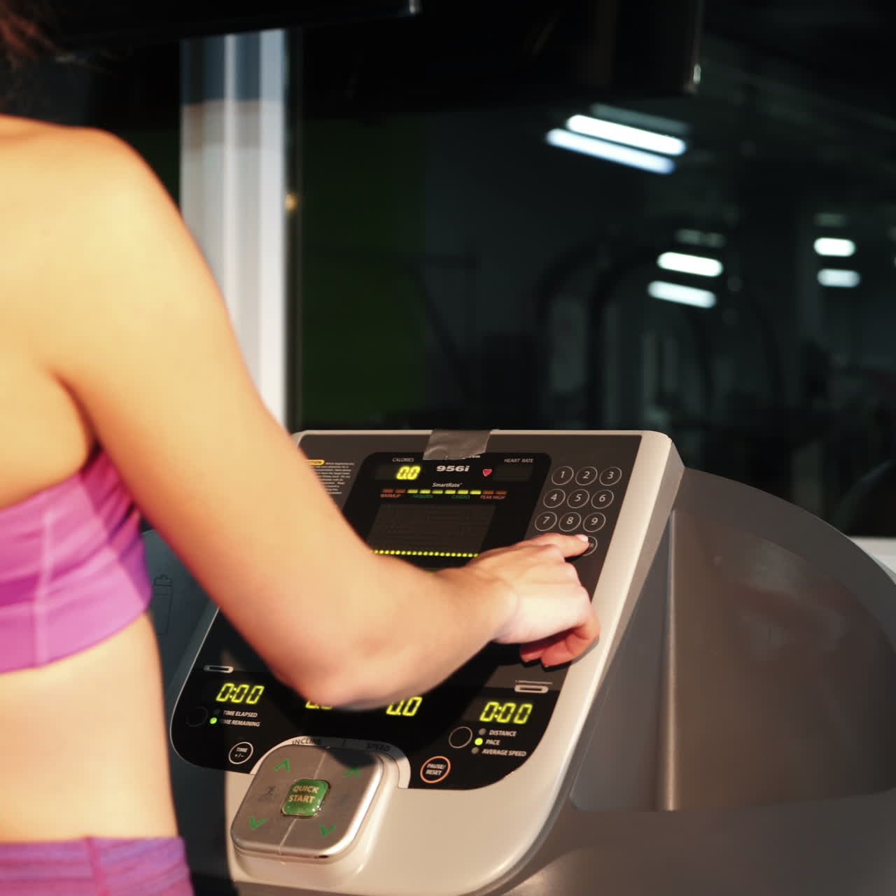 Fitness woman walking on treadmill for cardio training in gym club. Sports woman using screen on treadmill for settings cardio exercise in sports club Square video