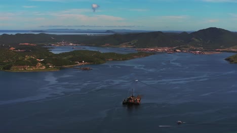 Ela-Beach-Port-Moresby-Papa-Papua-New-Guinea-Aerial-drone-oil-rig-boat-blue-sky-stunning-sunny-morning-bay-coastline-hills-PNG-Capital-City-fishing-wharf-Harbor-Idlers-Bay-circle-left