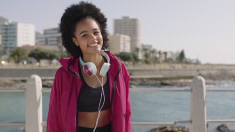 Retrato-De-Una-Atractiva-Mujer-Afroamericana-En-Ropa-Deportiva-Sonriendo-Alegre-En-Una-Hermosa-Y-Soleada-Playa