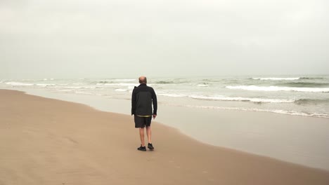 atleta masculino senior caminando cerca del mar