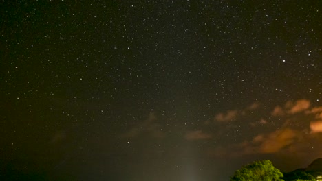 lapso de tiempo de las estrellas girando sobre el océano mientras las nubes de alta velocidad se mueven por el cielo