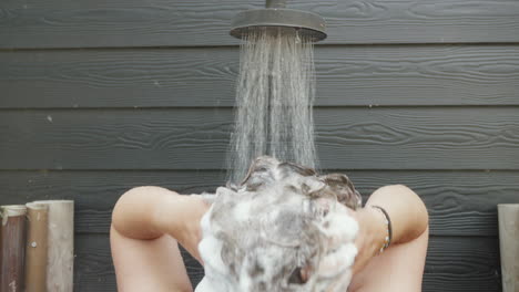 person enjoying refreshing outdoor shower. ideal for travel and lifestyle promotions.