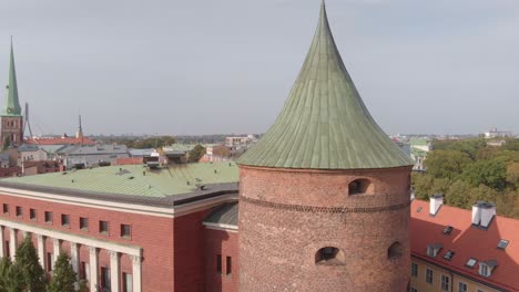 Rising-aerial-crossing-a-telephone-wire-viewing-the-Riga-Powder-Tower-in-Riga,-Latvia