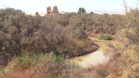 the jordan river winds through the countryside between jordan and israel