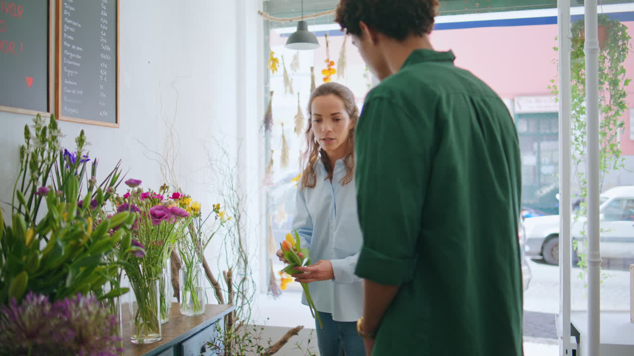 다민족 부부는 아름다운 꽃 가게에서 꽃받침을 구입합니다.