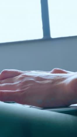 close-up of elegant female hand with manicured nails gently reaching for a laptop keyboard, showcasing modern technology and digital interaction