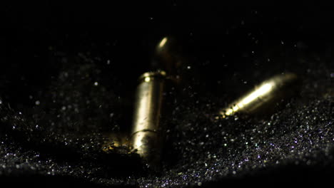 9×19mm parabellum and 300 aac blackout bullets falling on pile of gunpowder