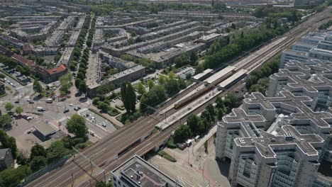 a top-down view of a modern urban area with trams, roadways, and residential housing in the hague.