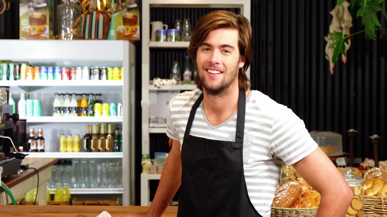 남자 웨이터가 으로 카운터를 청소하고 있다