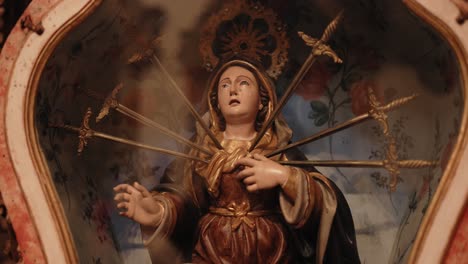 dramatic statue of our lady of sorrows pierced by seven swords, symbolizing grief