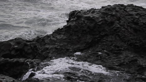 Las-Olas-Salpican-Contra-Las-Rocas-En-La-Playa-Islandesa-De-Arena-Negra