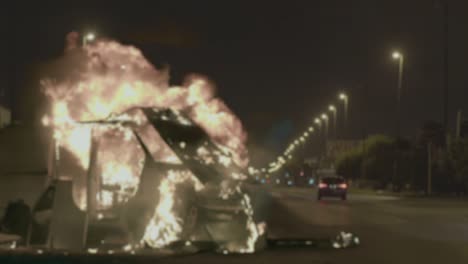 protestor holding old fashioned television green screen in front of a burning barricade outdoors. 4k resolution.