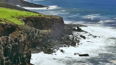 powerful waves crashing on volcanic coastline