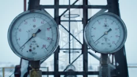 exploring the mechanisms of oil extraction: a detailed look at pumpjacks and pressure gauges in a cold environment