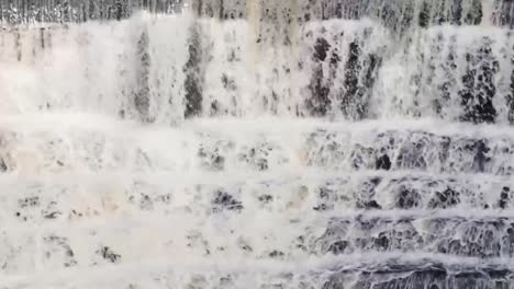 water running down stone stepped waterfall surrounded by trees and greenery-3