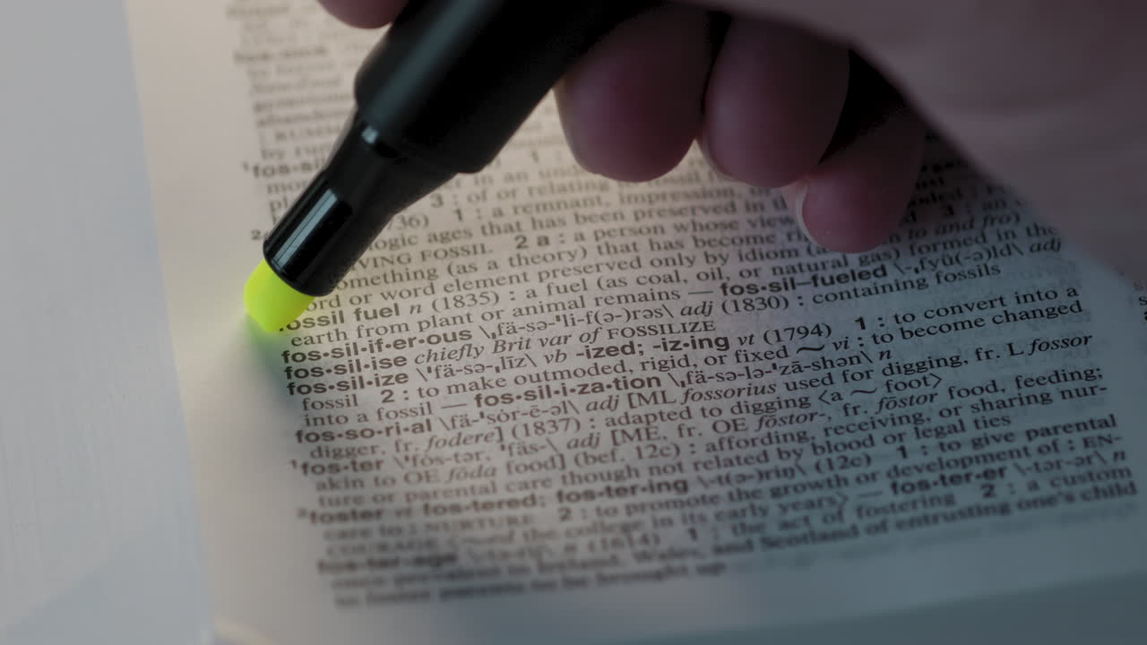 Fossil Fuel Environmental Dictionary Highlighter Concept, highlighting a word in a dictionary to show it's definition