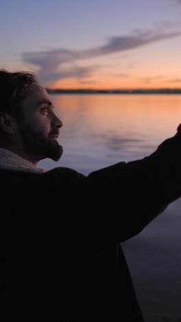 man contemplating sunset by the water