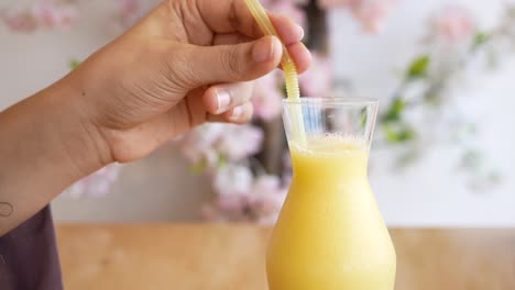 una mujer bebiendo un batido de mango.