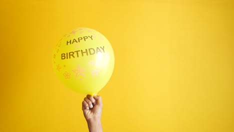 holding a ballon with birthday text