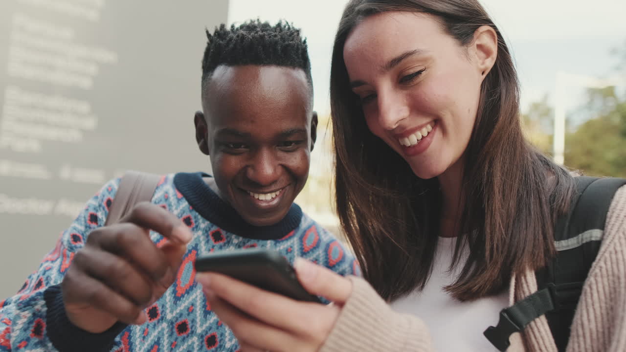 Amigos olhando para um celular e sorrindo