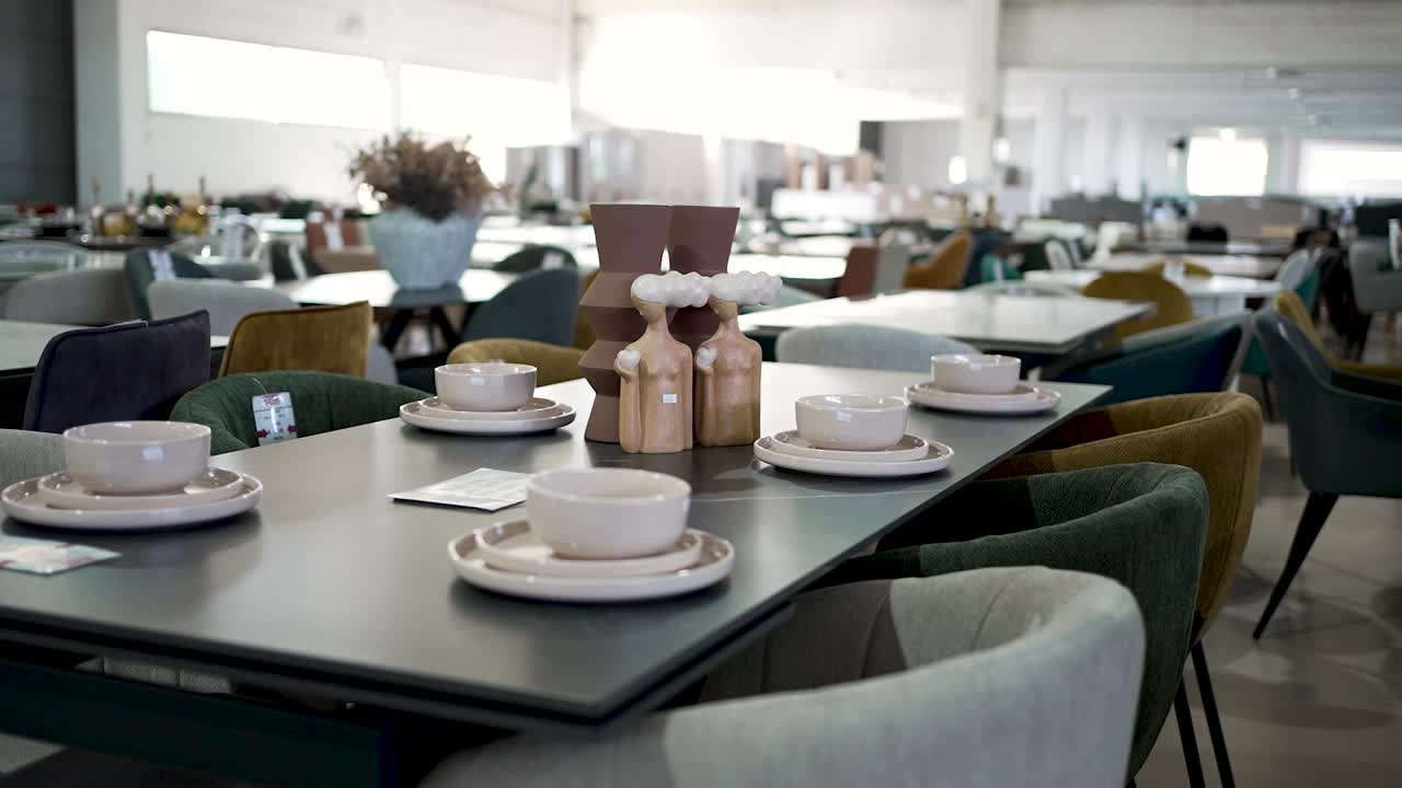 Explore a bright and open restaurant space featuring contemporary table arrangements. Dining tables showcase stylish plates and centerpieces ready for guests