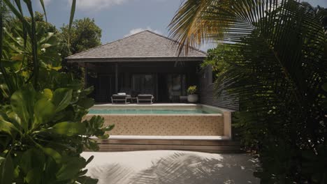 Luxuriöses,-Exotisches-Maledivisches-Apartment-Mit-Privater-Holzterrasse,-Sonnenliegen-Und-Swimmingpool-Am-Goldenen-Sandstrand-Mit-Grünen-Palmen-Und-Blauem-Himmel