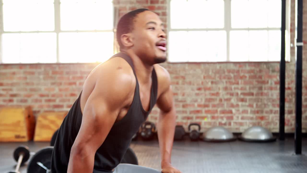 무거운 검은색 덤벨을 들어 올리는  ⁇ 한 남자