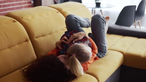 madre y niño pequeño niña en edad preescolar disfrutando de la vinculación divirtiéndose en el sofá