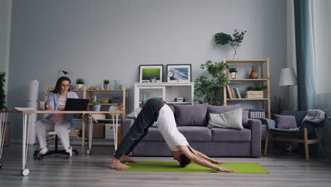 couple practicing yoga at home while working from home