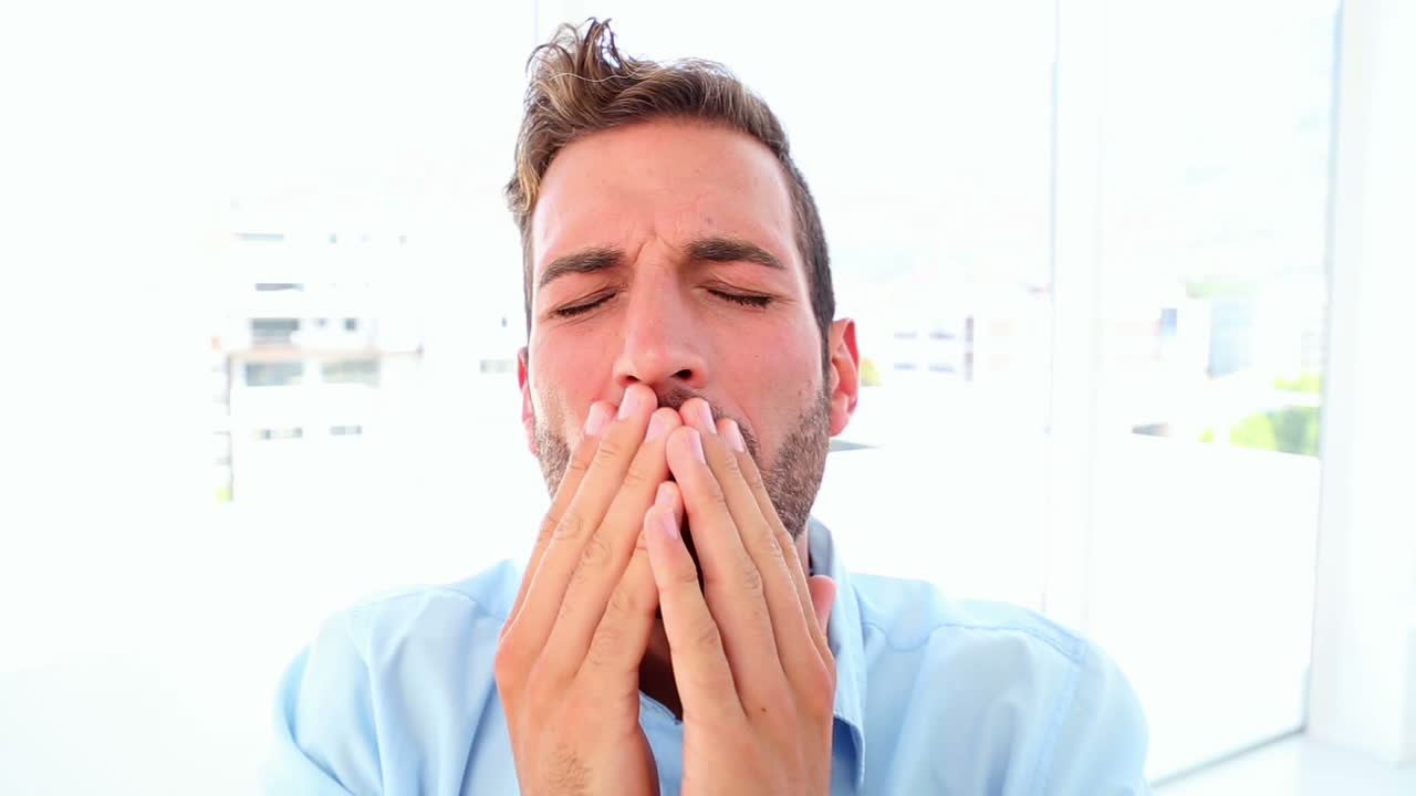 un hombre de negocios cansado bostezando y quedándose dormido.