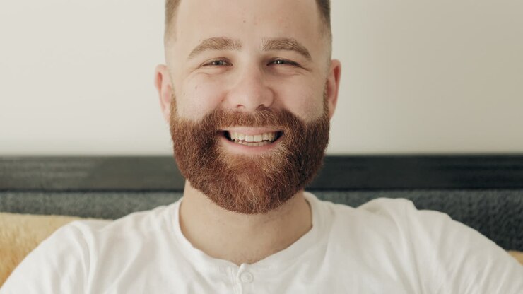 Close-up of Happy Young Bearded Man Smiling at Camera