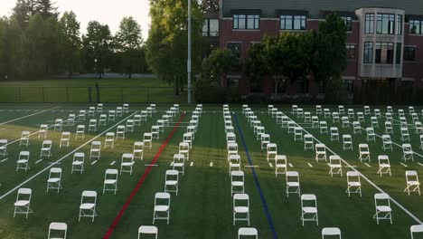 rows of vacant chairs arrange on an open field for graduation ceremony of university