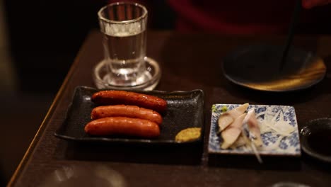 sequential preparation and serving of sausages on a hot plate