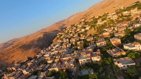 lebanon village in dry canyon hillside lit by golden sunlight glowing rays