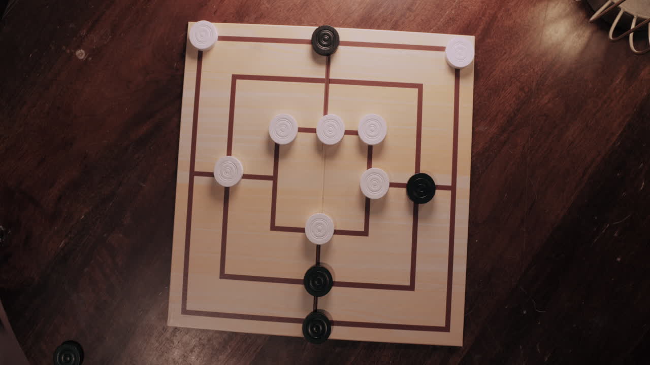 Person Moving Pieces on a Nine Men's Morris Board
