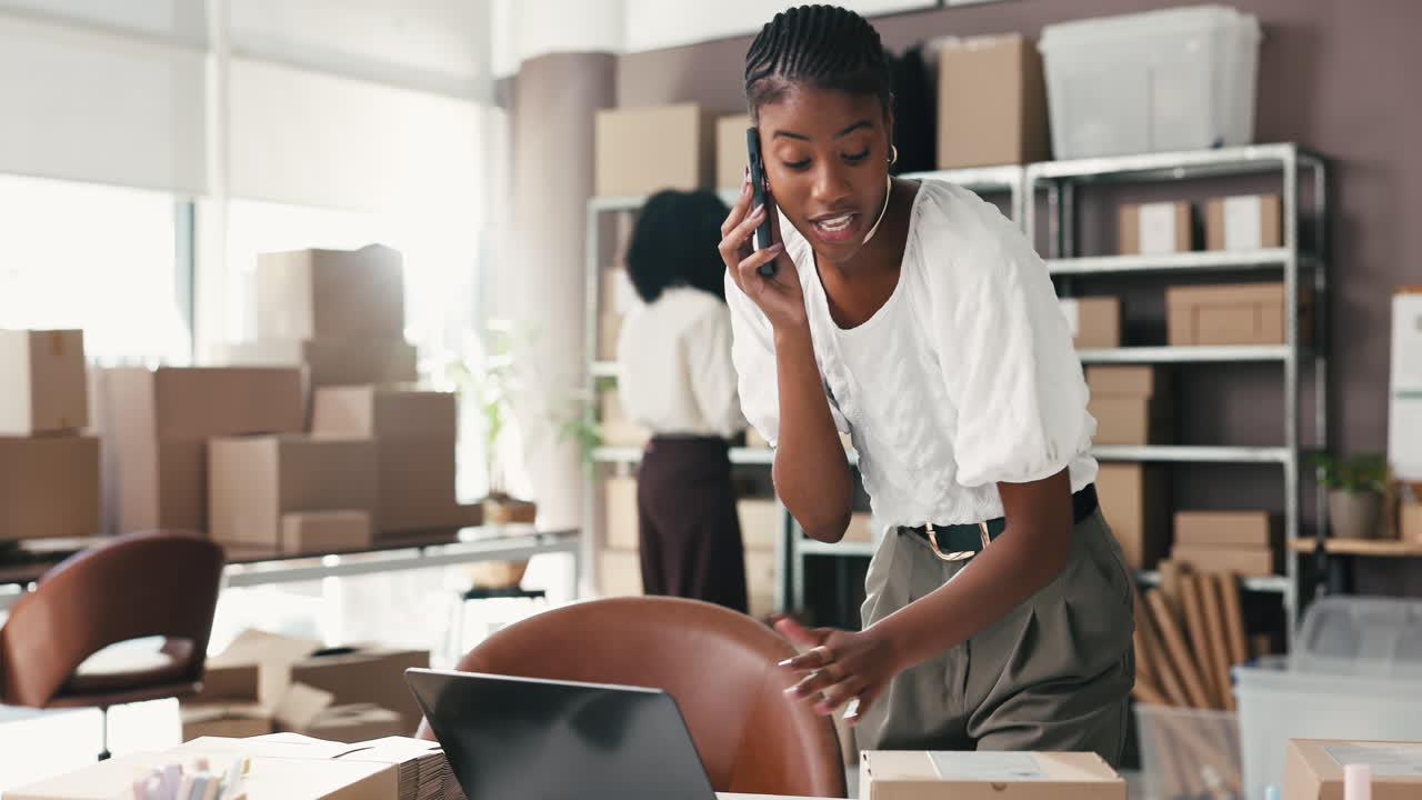 Giovane donna in telefonata lavora al laptop in un ufficio e-commerce