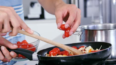 una pareja joven cocinando.