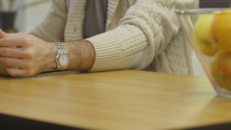 Un-Hombre-Sentado-En-Una-Mesa-Abre-Su-Computadora-Portátil-Y-Comienza-A-Escribir